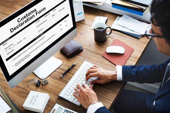 A man typing on a computer keyboard with a customs declaration form on the screen, highlighting the importance of immigration case management.